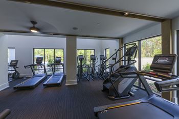 Fitness center with cardio equipment and large windows
